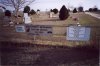 Signs hanging on the chain link fence of the TCM cemetery.